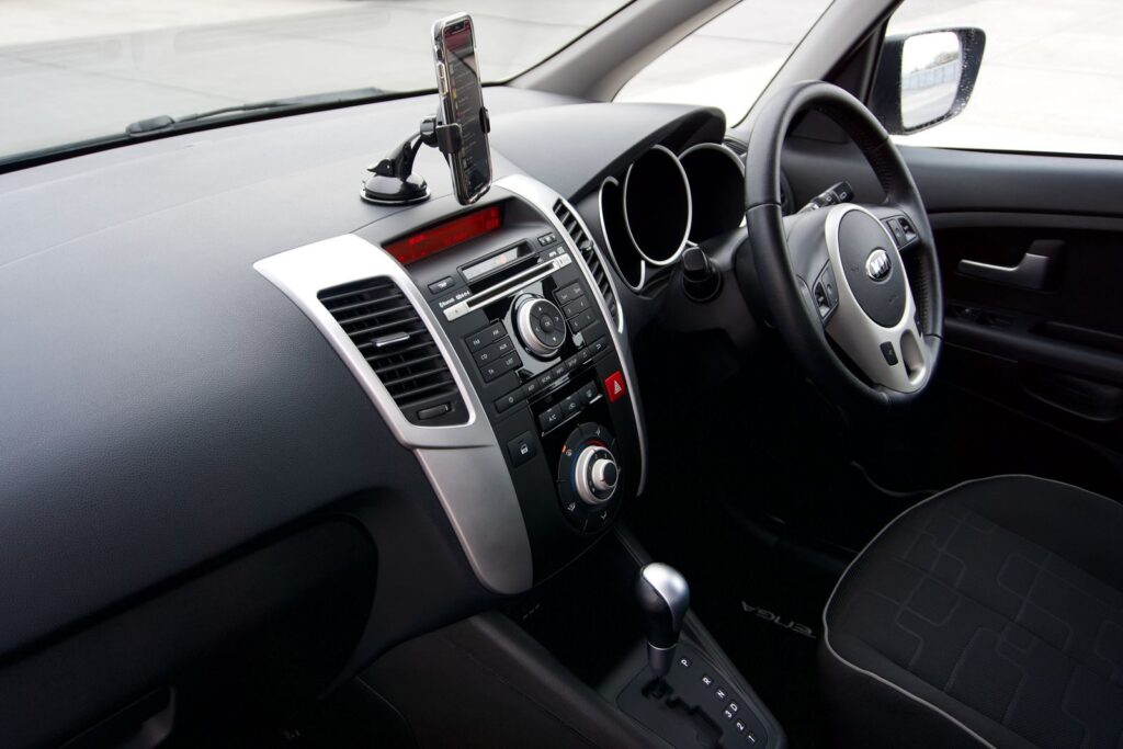 Sleek car dashboard with smartphone mount, steering wheel, and controls. Ideal for modern automotive design themes.