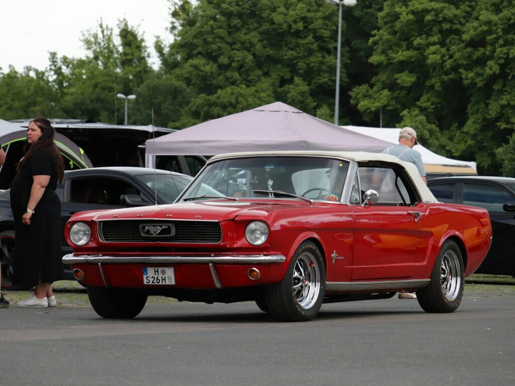 A classic red ford mustang convertible parked outdoors