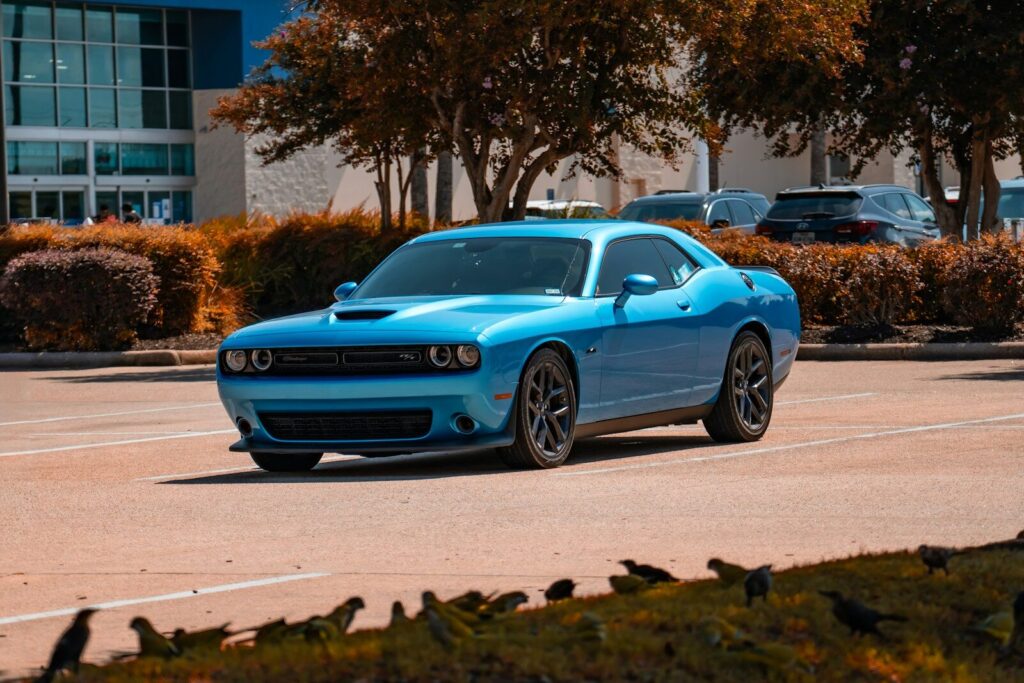 A blue dodge challenger parked outside a building
