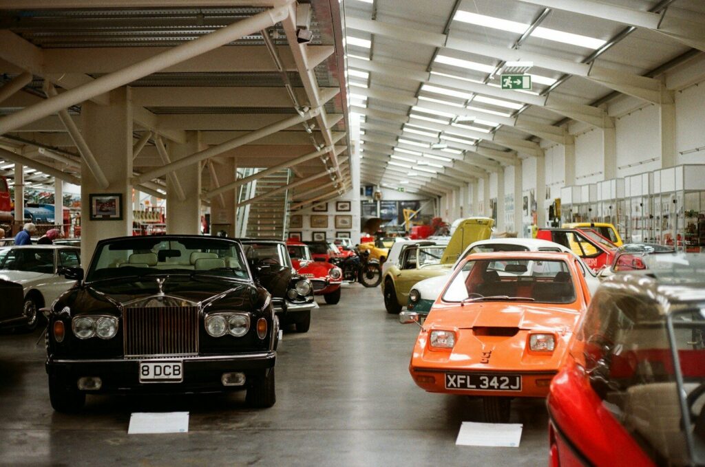 Collection of vintage cars and motorcycles displayed indoors