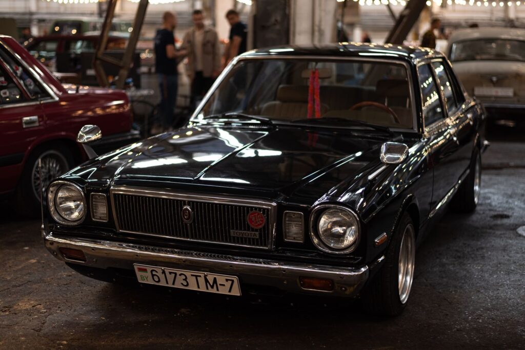 A vintage Toyota Corona Mark II displayed at an indoor car meet, showcasing its classic design.