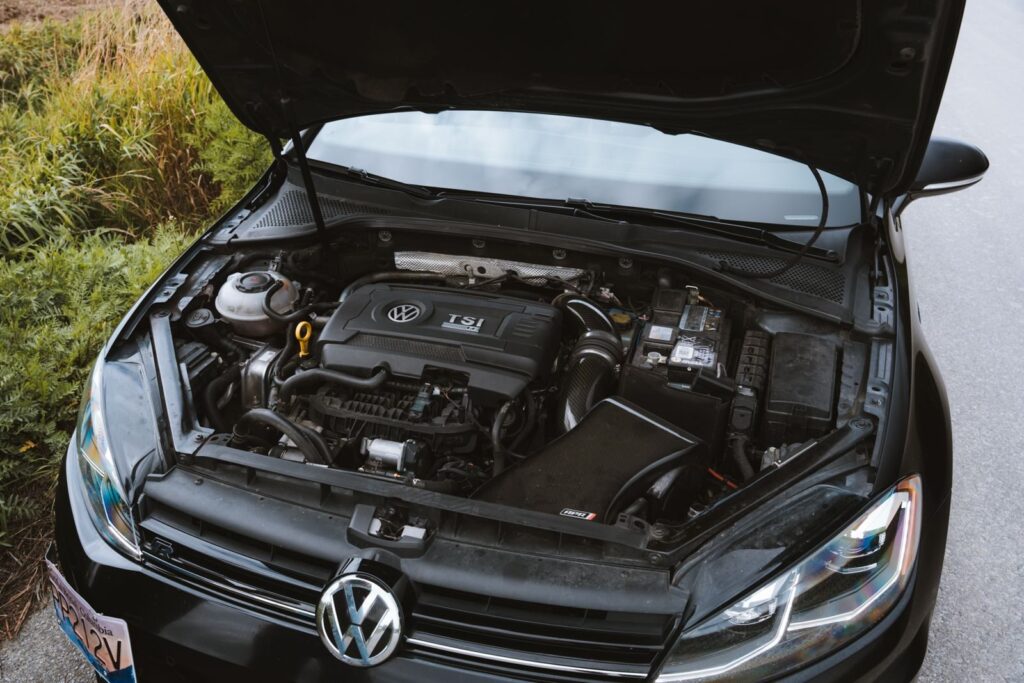 Close-up view of a Volkswagen car engine with the hood open, showcasing detailed components.
