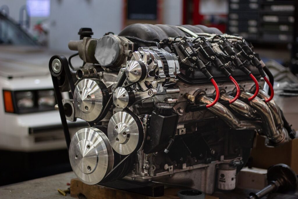 Detailed shot of a powerful car engine in a garage setting, highlighting mechanical components.