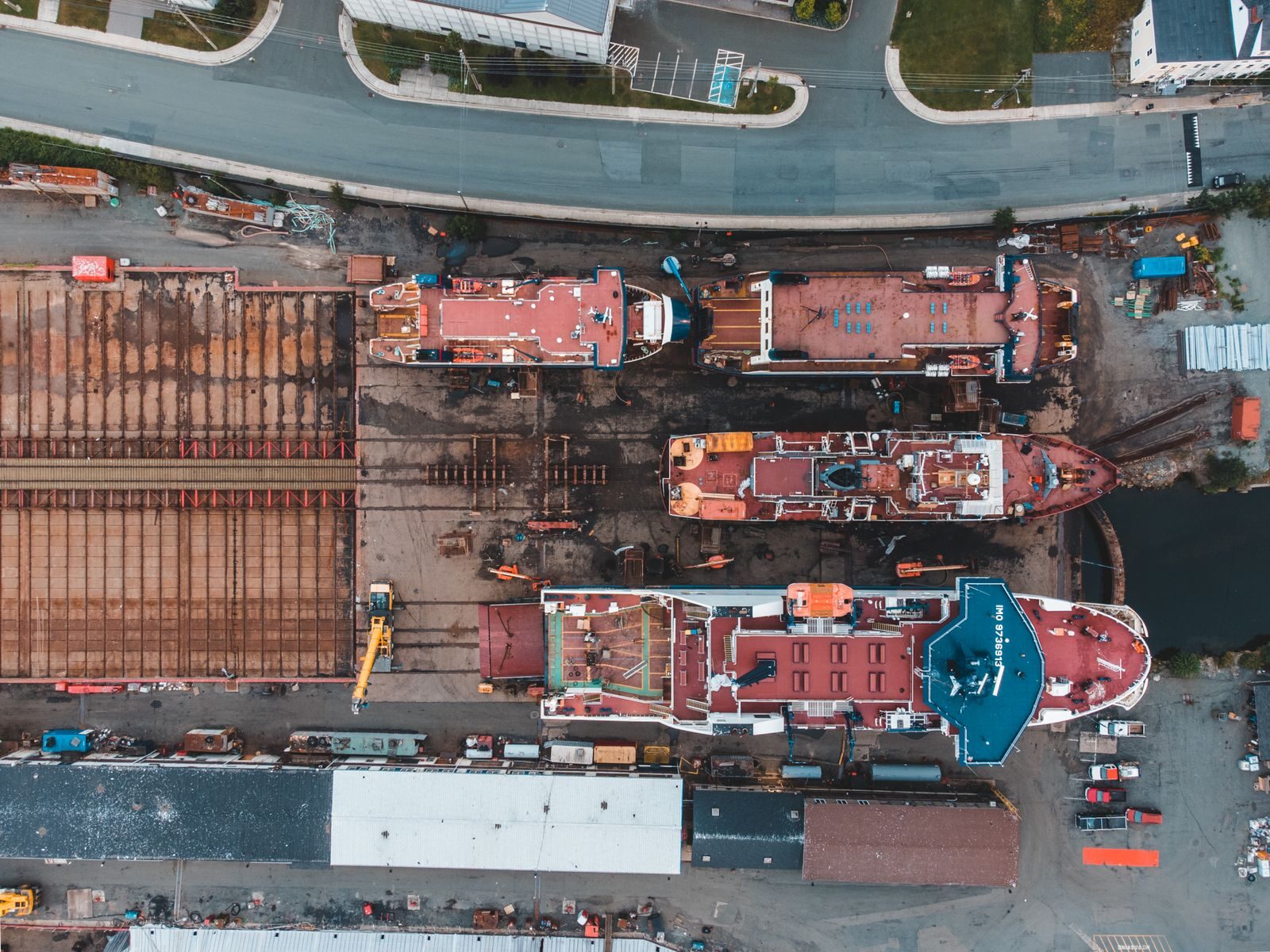 Drone shot of shipyard showcasing docked vessels and heavy machinery from above.