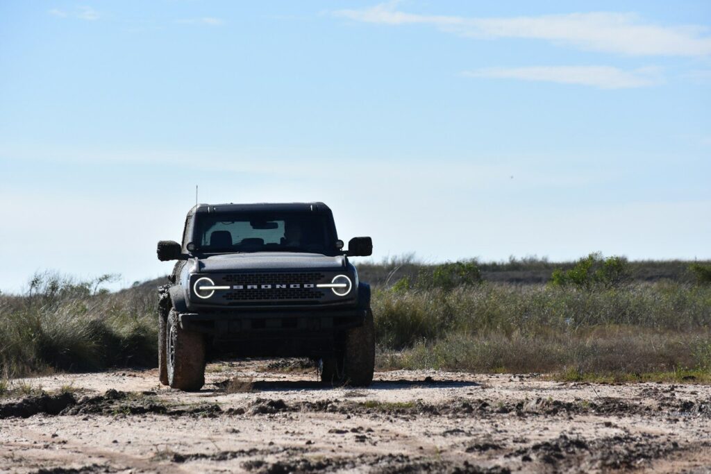 a black truck driving down a dirt road